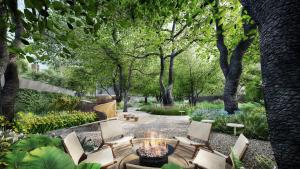 加尔加ZANA - A Luxury Escape, Dhikuli, Jim Corbett的花园内的一个火坑,花园内种有椅子和树木