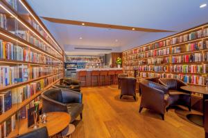 阿姆斯特丹大使酒店的图书馆配有皮椅和书架