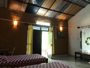 坎哈Kamp Kamouflage Kanha的客房设有两张床和一扇窗户的门