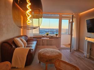 奥格斯堡Stylische Sunset-Wohnung的客厅设有真皮沙发和大窗户