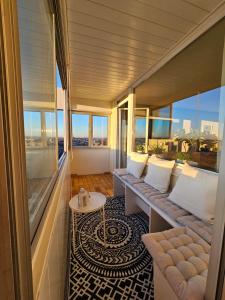 奥格斯堡Stylische Sunset-Wohnung的阳台配有沙发、桌子和窗户。