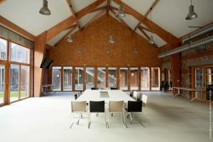 Arleux-du-NordLa Ferme Des Ailleurs的一间会议室,配有大桌子和椅子
