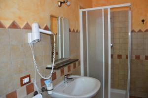 多尔加利Hotel Sant'elene的浴室配有盥洗盆和带镜子的淋浴