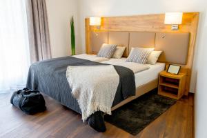 克桑滕Landhotel Lebensart的一间卧室配有一张大床和木制床头板