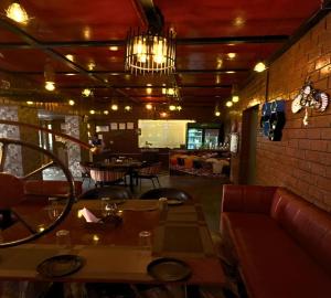 Pura RaghunāthHotel Runway Inn的餐厅配有沙发、桌子和吊灯