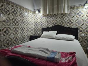 拉巴特Dar Ba sidi的卧室配有一张带红色毯子的白色床