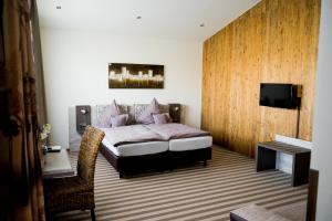 克桑滕Landhotel Lebensart的一间卧室配有一张床和一台平面电视