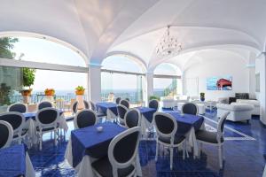 普莱伊亚诺玛丽亚皮亚别墅酒店的配有蓝色桌椅和窗户的客房