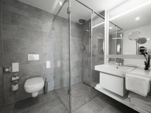 柏林Grimm's Potsdamer Platz的浴室配有卫生间、盥洗盆和淋浴。