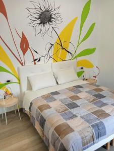 卡萨诺韦Sleep & Fly Villa Luisa的卧室配有一张挂着花壁画的床。