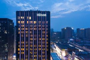 南京南京希尔顿酒店的一座高大的建筑,在城市里,上面有摩尔顿标志