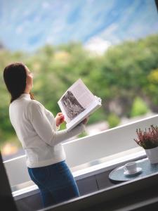 蒂瑟达尔Trolltunga Aparthotel的女人在窗户上读书