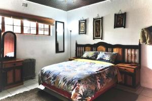 内尔斯普雷特Leopards Ledge的一间卧室配有一张带木制床头板的床