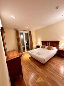 马尔蒂内特Acogedor alojamiento en Martinet, Cerdanya.的卧室配有一张白色的大床,铺有木地板