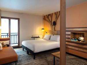 里雾诗ibis Styles Les Houches Chamonix的酒店客房设有一张床和一个阳台。