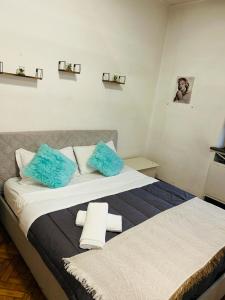 米兰Central Apartment Milano的一间卧室配有两张带蓝色枕头的床。