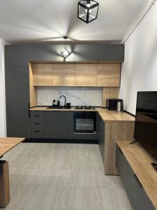 普雷代亚尔Apartament Bonton Predeal的厨房配有木制橱柜和炉灶烤箱。