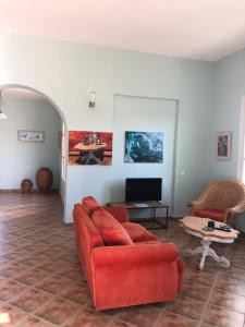 加夫里翁Villa Il Paradiso Andros的客厅配有红色的沙发和桌子