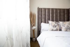 约翰内斯堡Maboneng Modern Style的一间卧室配有带白色床单和枕头的床。