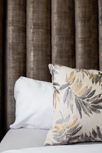 约翰内斯堡Maboneng Modern Style的一张带白色枕头和枕头的床
