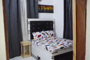 达累斯萨拉姆2 Bedroom spacious Cozy Home in Kigamboni,10 min Walk to Beach的一张小床,位于带黑色窗帘的房间