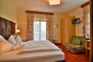 埃尼亚威尔内霍夫酒店的酒店客房带一张大床和一把椅子