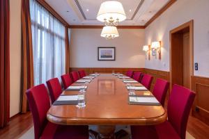 威廉港威廉港大西洋酒店的一间会议室,配有长桌子和红色椅子