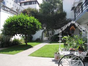 墨西哥城卡萨冈萨雷斯酒店的一座花园,旁边是一座建筑物,花园内有一辆自行车停放