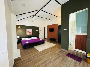 卡尔佩特塔Western Ghats Holiday Home的一间带紫色床的卧室和一间浴室