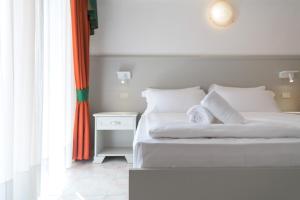 利莫内-苏尔加达加尔达贝尔维尤酒店的卧室配有白色的床和白色床头柜