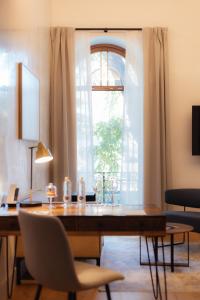 塞维利亚Cavalta Boutique Hotel GL的一间带桌子和窗户的用餐室