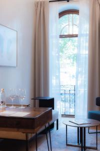 塞维利亚Cavalta Boutique Hotel GL的客厅配有桌椅和窗户。
