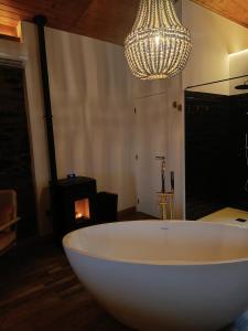比索达雷加Casa do Romezal的配有吊灯的客房内的白色大浴缸