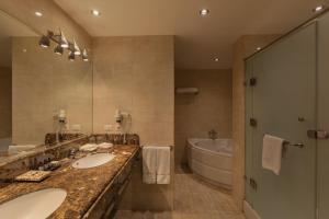 开罗Riverside Hotel的浴室设有2个水槽、浴缸和镜子