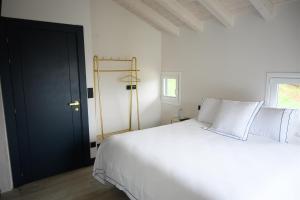 格尔尼卡Hotel Neguetxea的卧室配有白色的床和黑色的门