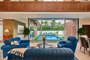 罗纳瓦拉EKOSTAY - Luxe - La Casa Grande的客厅配有蓝色家具和游泳池