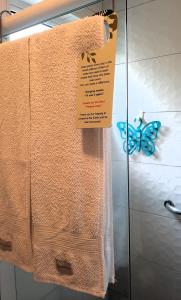 伊利亚贝拉Suítes Cambucá的一条毛巾和一个带蝴蝶的玻璃门上的标志