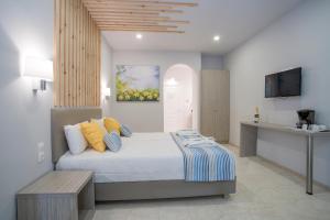 卡拉马孔Cavo Doro的一间卧室配有一张床、一张桌子和一台电视。