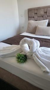 丹吉尔Appart Hotel Tanger Paname的一张带两条毛巾的床,上面有绿色植物