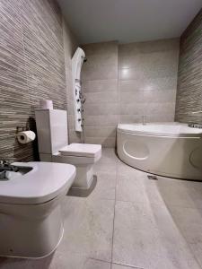PernikХотел Антик的浴室配有卫生间、浴缸和水槽。