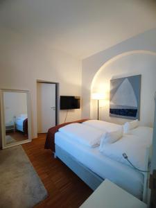 林茨阿姆多姆广场酒店 - 仅限成人入住的卧室配有一张白色大床和镜子