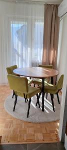维舍格勒Apartman Minja的餐桌、绿椅和桌子