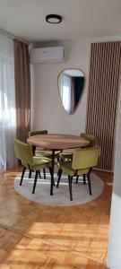 维舍格勒Apartman Minja的一间带桌椅和镜子的用餐室