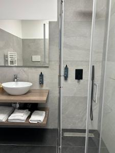 布鲁纳特Hotel Paradiso Como的一间带水槽和玻璃淋浴的浴室