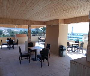亚喀巴La Riva Hotel的餐厅设有桌椅,享有艾菲尔铁塔的景色