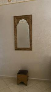 迈尔提勒Luxury appartment Oumi的一面白色墙壁上的镜子,一面有木箱