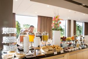 格丁尼亚格丁尼亚美居中心酒店的餐桌上的自助食品和饮料