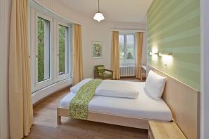 布里格Hotel Haus Schönstatt contactless-Check-In的一间卧室设有两张床和两个窗户。