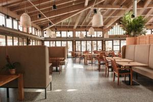 MagliasoCentro Magliaso的餐厅设有木桌、椅子和窗户。