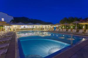 卡拉马孔Cavo Doro的游泳池在晚上提供椅子和遮阳伞